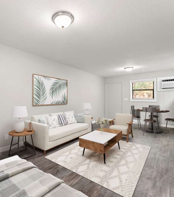 A living room with a couch, chair, and coffee table at Balfour 296 Apartments in Lilburn, Georgia, 30047