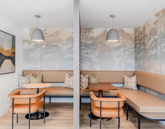 A modern dining area with a large mural on the wall.
