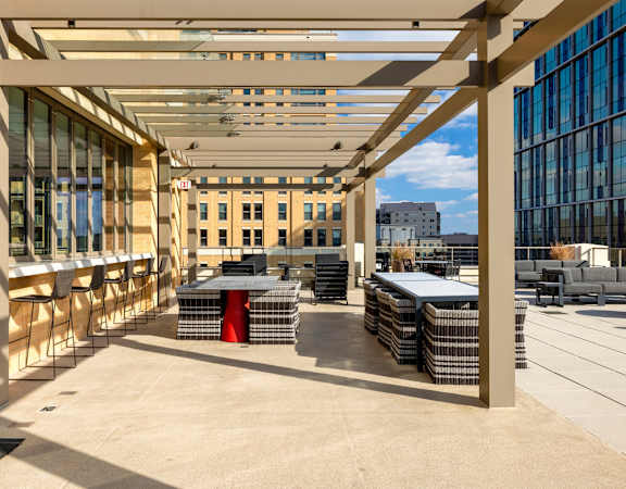the terrace of the building has tables and chairs under awning at The Bartlett in Arlington, VA 22202