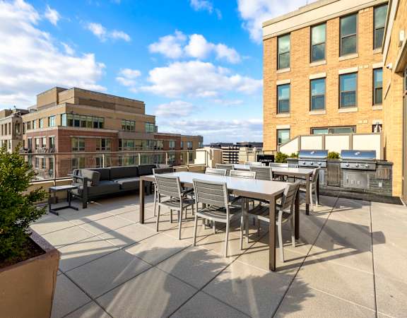 a patio with a table and chairs on a rooftop at The Bartlett in Arlington, VA 22202