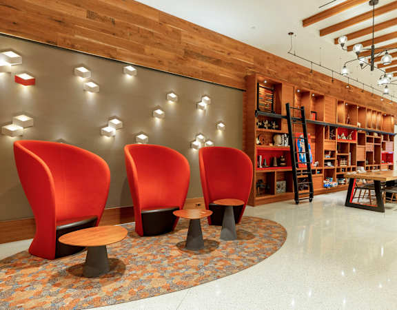 the lobby of a store with red chairs and tables at The Bartlett in Arlington, VA 22202