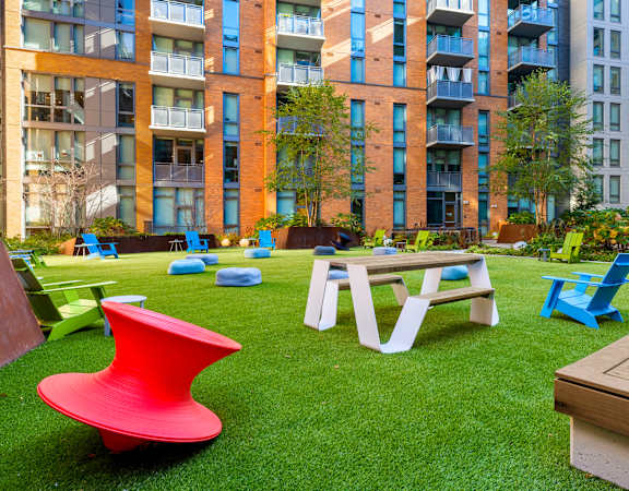 a rendering of an apartment yard with a picnic table and chairs