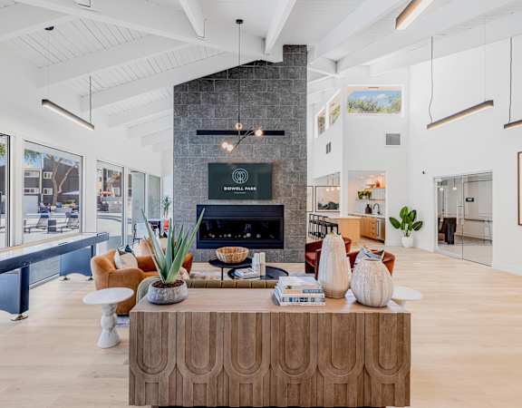 A modern living room with a fireplace and a large wooden coffee table.