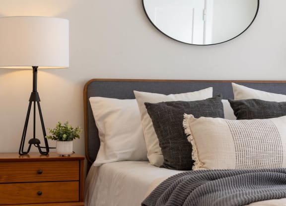 a bedroom with a bed with pillows and a mirror on the wall at Oakwood Manor in Bay Shore, NY 11706