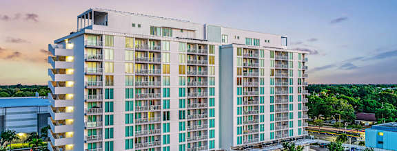 A large, modern hotel building with a parking lot in front.