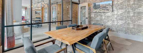 A dining room with a wooden table and grey chairs.