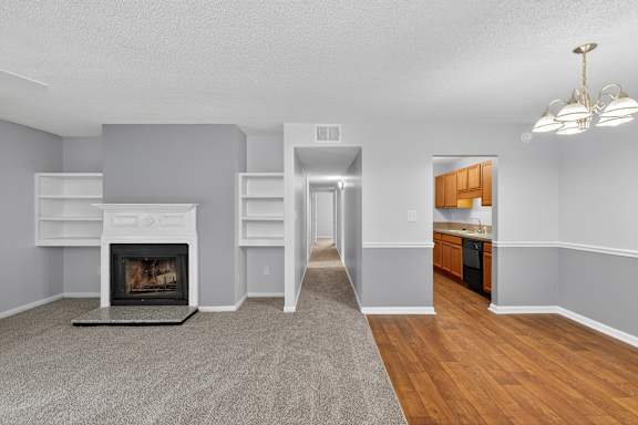 A spacious room with a carpeted floor and a ceiling fan. at North Bluff Apartments, North Charleston