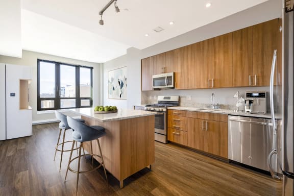 a kitchen with wooden cabinets and stainless steel appliances at The Bartlett in Arlington, VA 22202