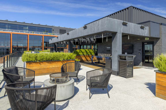 a patio with chairs and tables outside of a building