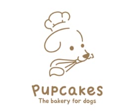 the bakery for dogs logo with a cartoon dog playing with a bow