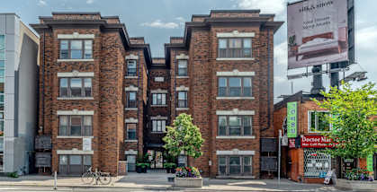 A red brick building with a green tree in front of it. at 723 Bloor Apartments, Toronto, CA