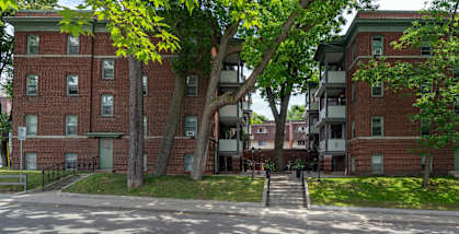 A red brick apartment building with a tree in front.at 83-85 Silver Birch, Toronto, CA