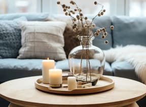 a living room with a table with candles and a vase with flowers