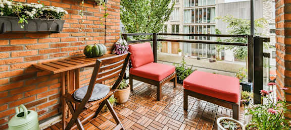 a balcony with a table and chairs and a window