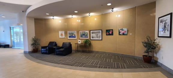 a lobby with chairs and pictures on the wall