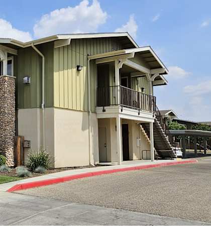 an apartment building with green walls and a sidewalk