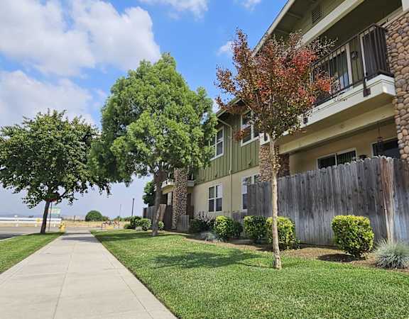 an apartment building with a sidewalk and trees