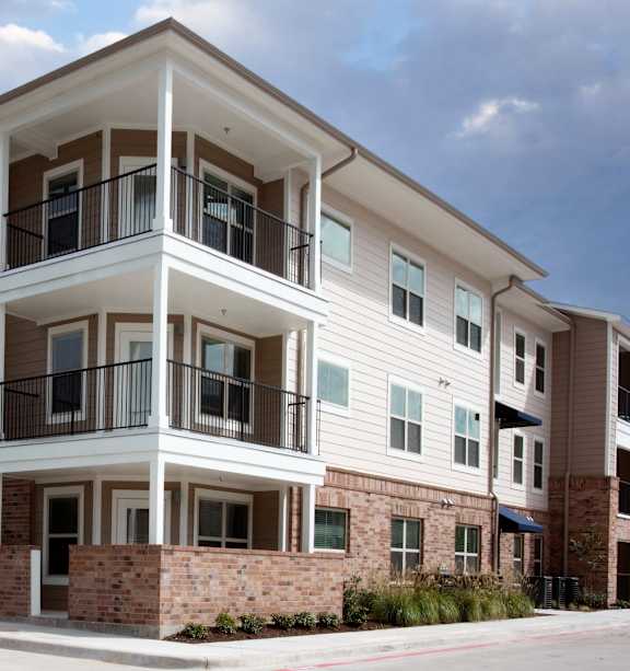 Apartment building with a car parked in front.