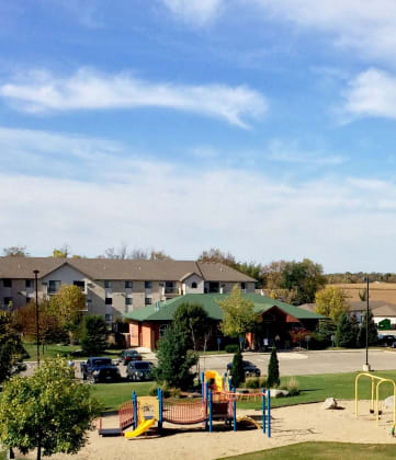 a park with a playground and apartment buildings in the background