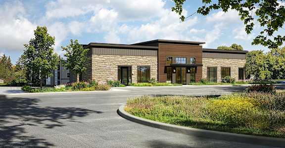 A modern building with a parking lot in front.