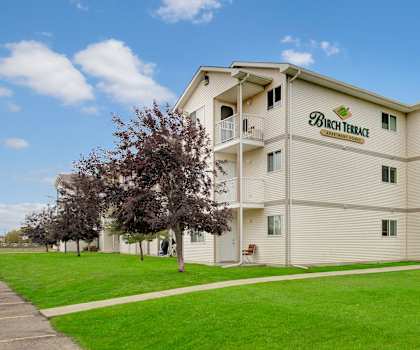 The exterior of Birch Terrace Apartment Homes surrounded by green space. 
