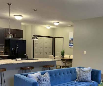 a blue couch in a living room next to a kitchen at North Pointe Villas Apartments, Lincoln
