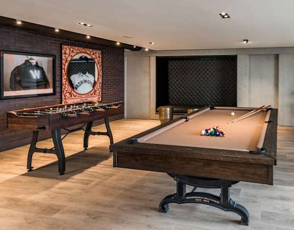 a pool table in a room with tables and a tv