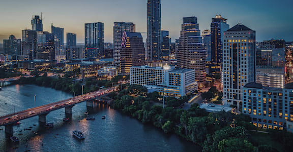 A cityscape at dusk with a river running through it.