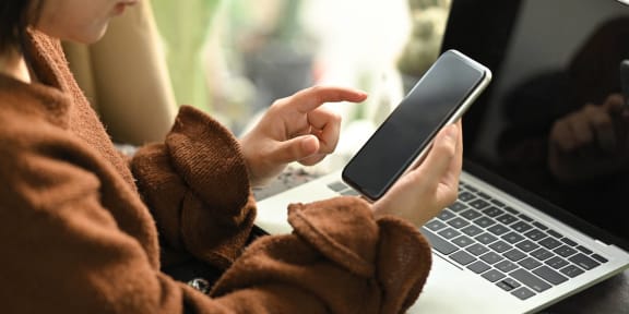 a woman sitting on a couch looking at her cell phone