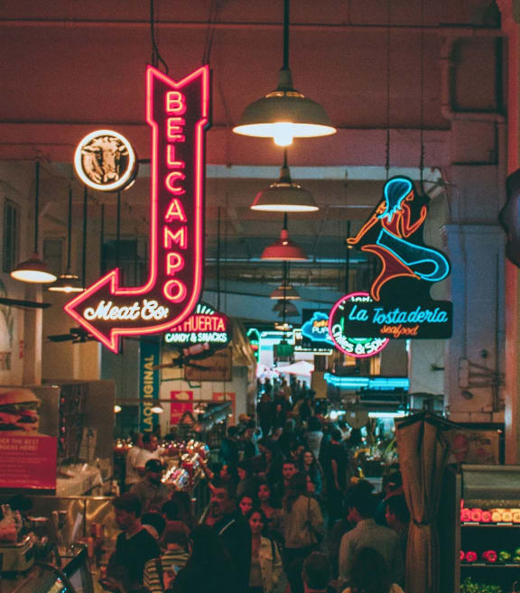 a crowded market with neon signs in a building