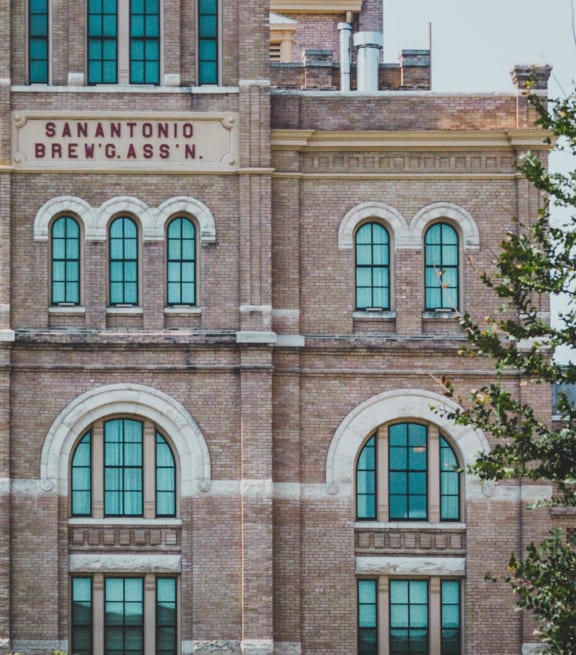the front of a brick building with green windows