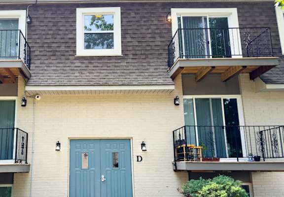 A building with a blue door and windows with balconies.