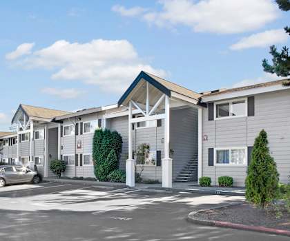 The outside of the buildings with stairs leading up to individual homes and plenty of parking for residents at Lake Park Apartments. 