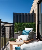 a balcony with two chairs and a table and a window