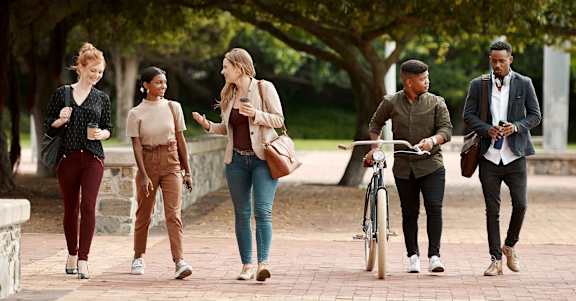A group of five people walking in a park at Ophelia on Queen Apartments, Ontario, N2G 0E7