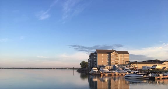 A serene waterfront scene with a building and boats docked in the foreground.