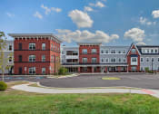 Thumbnail 1 of 6 - an exterior view of an apartment complex with a parking lot