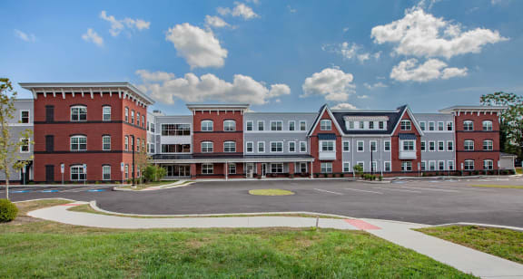an exterior view of an apartment complex with a parking lot