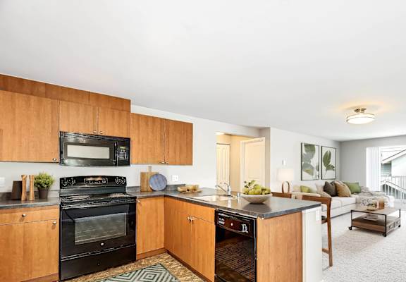 A kitchen with wooden cabinets and a black oven.