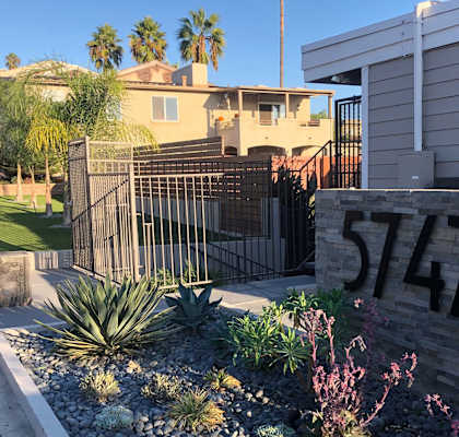 a home with a black gate and a stone wall with the number 514 on it