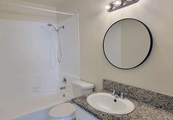 A bathroom with a toilet, sink, and shower.