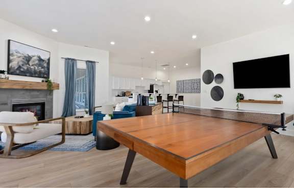 A modern living room with a wooden table and blue chairs.