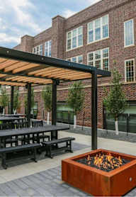A modern outdoor seating area with a fire pit in the center.