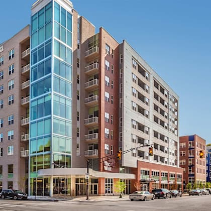 A modern multi-story building with a glass facade is the main focus of the image.