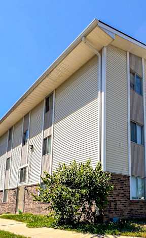 A modern apartment building with a clear blue sky above at The Ridges Apartments, Des Moines, IA