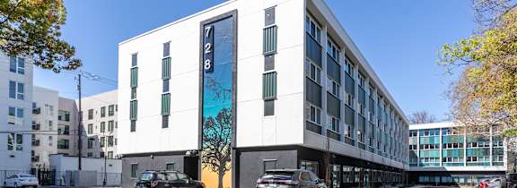 large building with cars parked in front of it at THE MOD AT MIDTOWN Apartments, CA