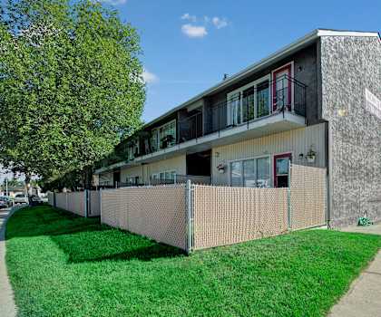 Exterior of Broadmoor Apartments with a lawn and buildings. 