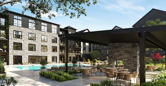 A modern building with a pool and outdoor seating area.