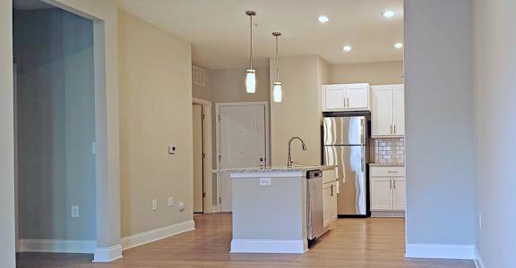 A kitchen with a white island and stainless steel appliances.