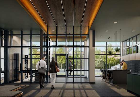 A modern interior with people walking through a glass doorway.